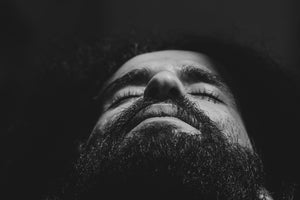 man who used beard oil facing up to the sky with eyes closed